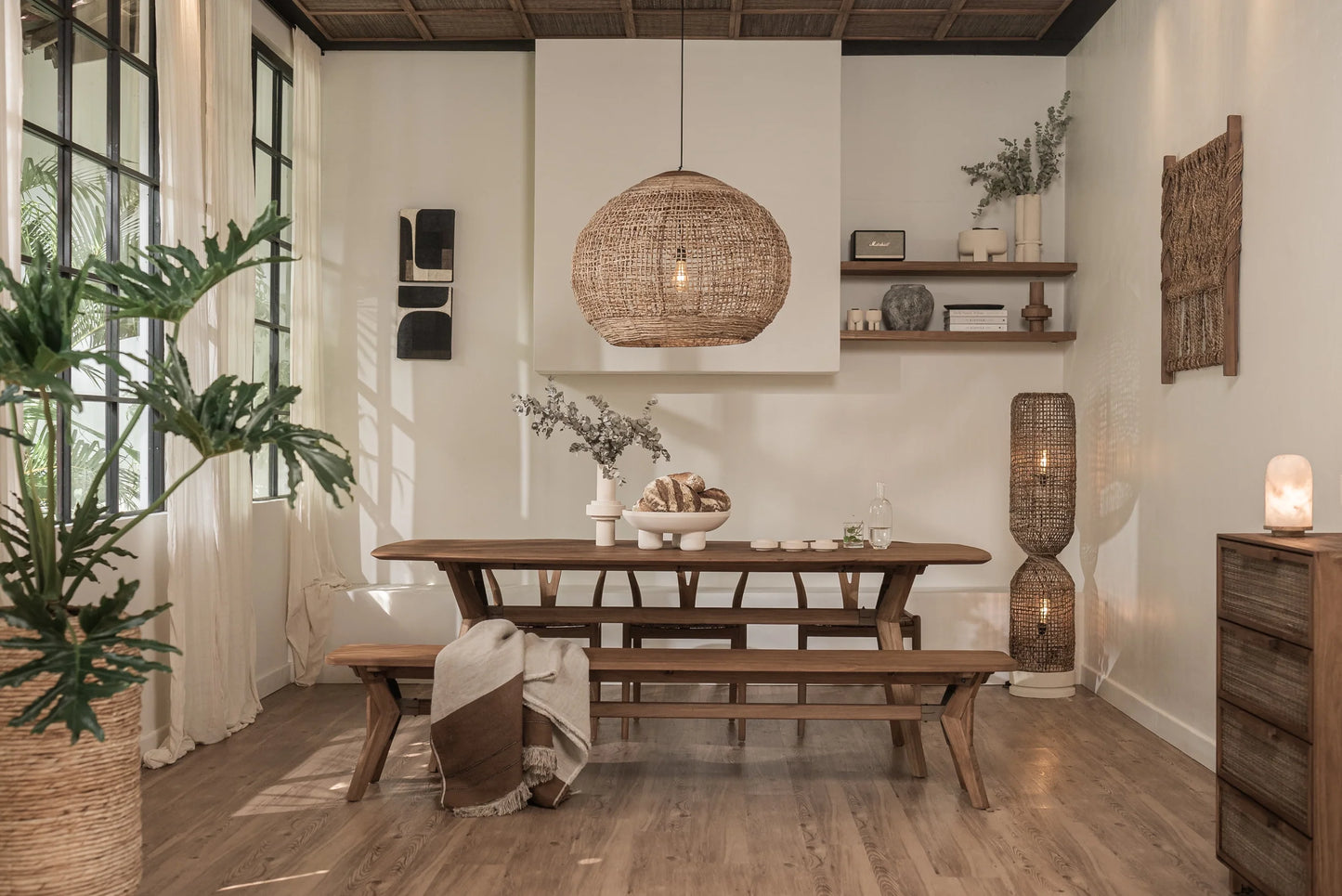 Vue de la table de cuisine en bois massif de teck recyclé Kupu Kupu Ellipse de la collection CRUSOË X dBodhidans une salle à manger au décor tropical mid-century